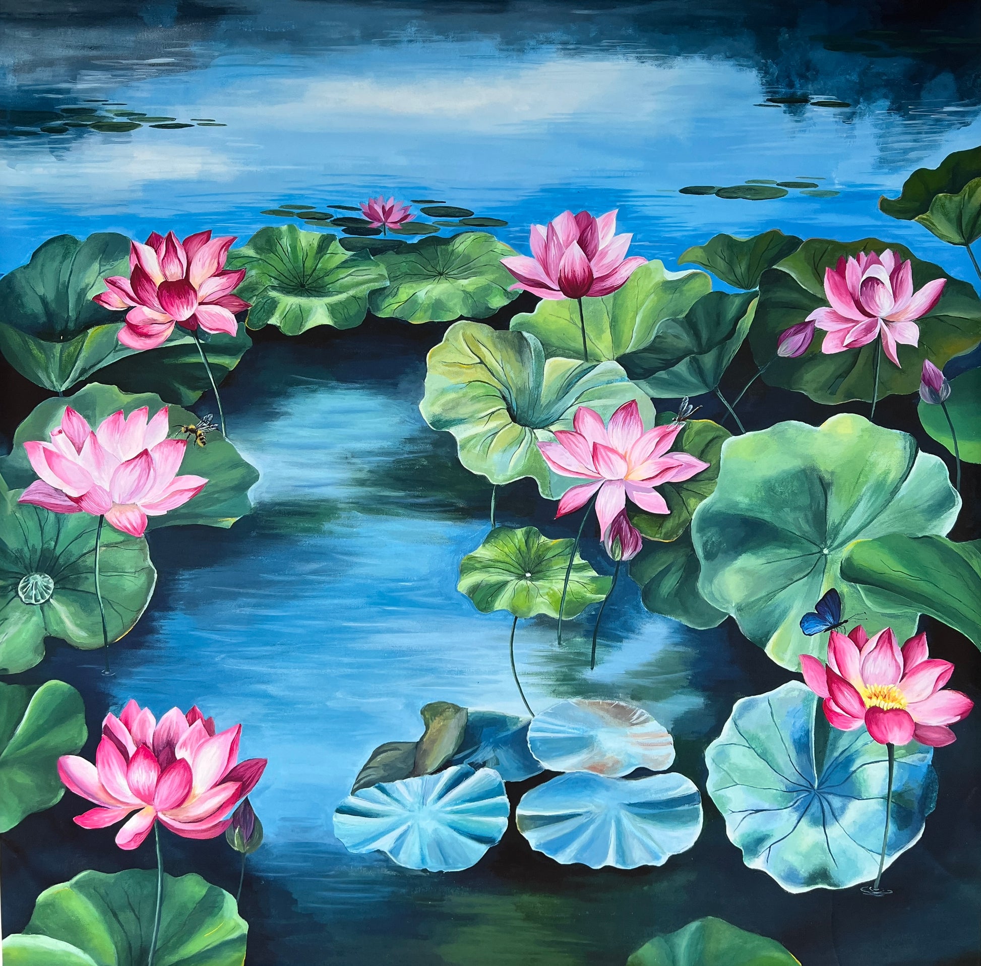 Lotus canvas painting featuring pink lotuses and lush green leaves against a bright blue background. The artwork also includes a blue butterfly, a bee, and a dragonfly, adding symbolic elements of nature and transformation.